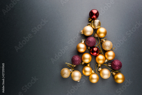 Christmas tree made of Christmas balls on black background. Minimal styled New Year banner.