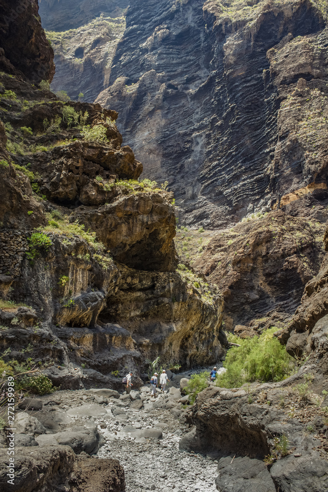 Rocks in the Masca gorge, Tenerife, showing solidified volcanic lava flow layers and arch formation. The ravine or barranco leads down to the ocean from a 900m altitude.