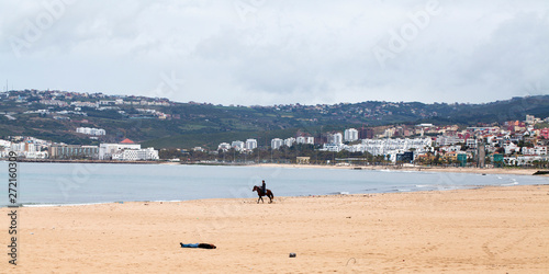 Caballo y jinete en la playa de Tánger, Marruecos