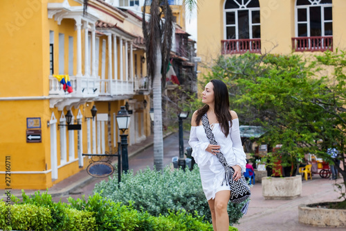 Beautiful woman on white dress walking alone at the walls surrounding of the colonial city of Cartagena de Indias © anamejia18