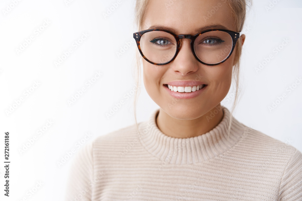 Girl adores new glasses picked in optician store standing happy and delighted against white background smiling satisfied and accomlished at camera. Valentines day, tenderness and beauty concept