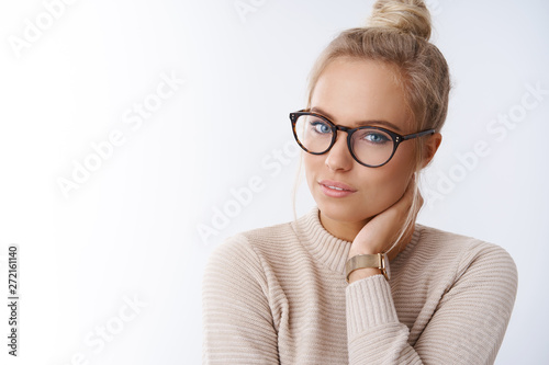 Sensuality, beauty and lifestyle concept. Attractive blond woman in glasses combed hair touching neck and tilting head looking gentle at camera as flirting, expressing relaxation carefree emotions