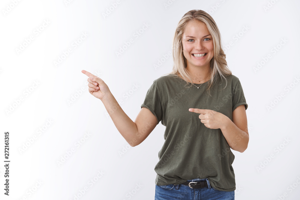 That is way. Portrait of friendly good-looking tanned european adult woman pointing left and smiling as inviting see yourself recommending product indicating advertisement over white background That is way. Portrait of friendly good-looking tanned european adult woman pointing left and smiling as inviting see yourself recommending product indicating advertisement over white background