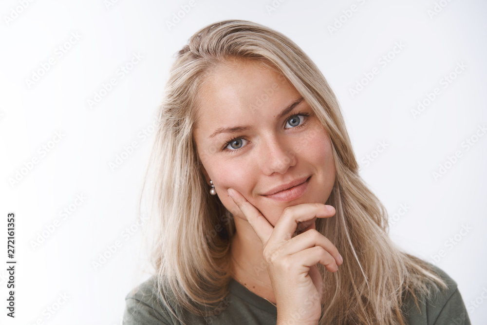 Lovely tender and feminine young wife tilting head cute and touching cheek with fingers smiling romanticly at camera touched with heartwarming valentines day gift over white background