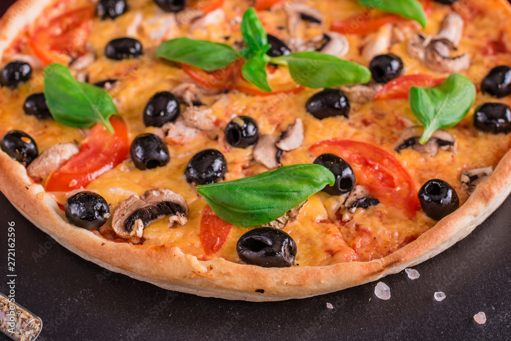 Tasty fresh hot pizza against a dark background. Pizza, food, vegetable, mushrooms Tasty fresh hot pizza against a dark background. Pizza, food, vegetable, mushrooms