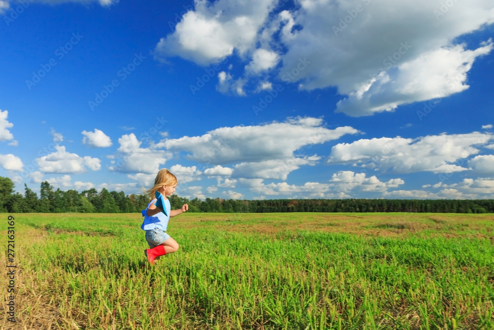Little girl holding a paper plane in a hand and running in a field. Little girl holding a paper plane in a hand and running in a field.