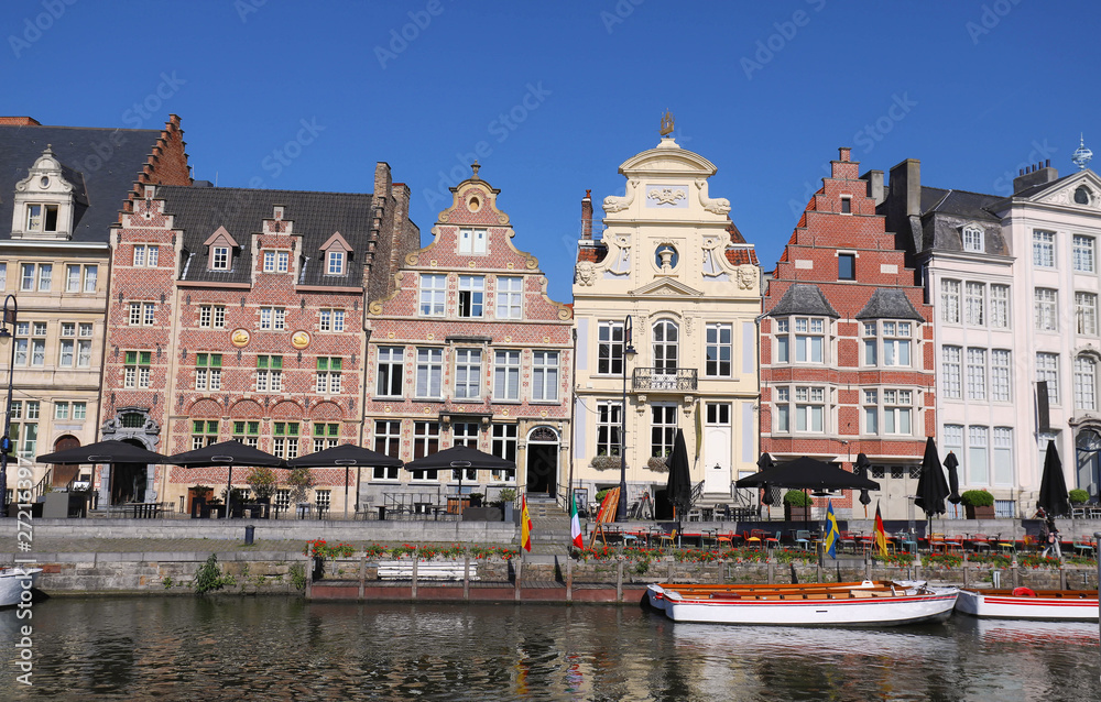 old colorful traditional houses along the canal and boats in popular touristic destination Ghent, Belgium