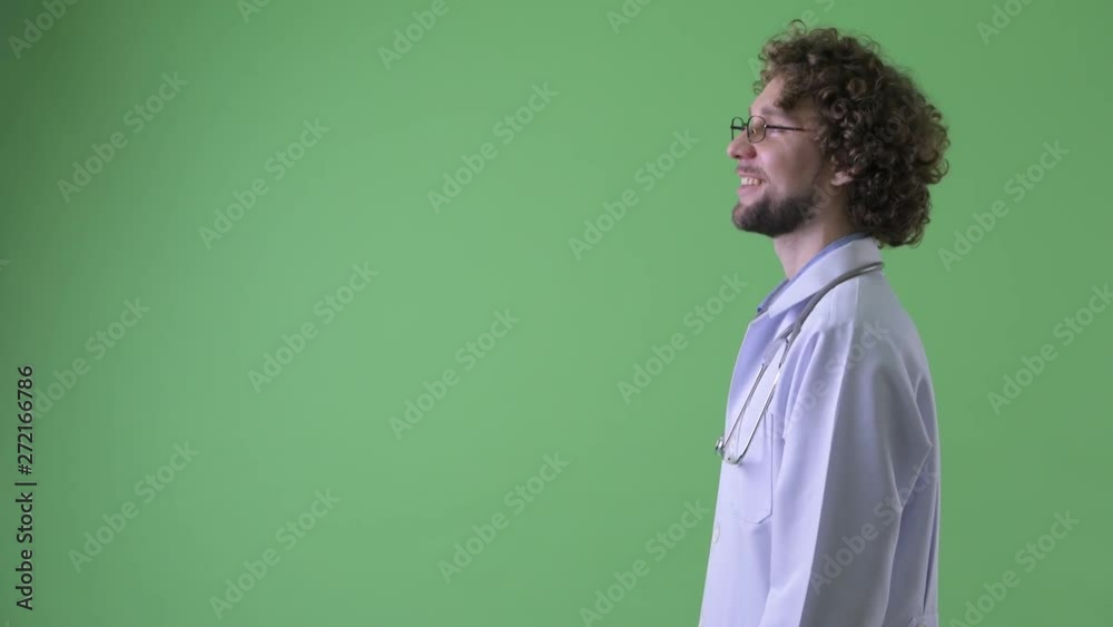 Profile view of happy young bearded man doctor thinking Profile view of happy young bearded man doctor thinking