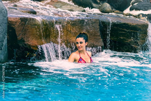 Woman bathing under a waterfall.