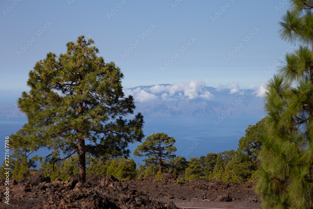 Island of La Gomera, partly covered by the clouds. Bright blue sky. View from 1900 meters of altitude. Teide National Park, Tenerife, Canary Islands, Spain.