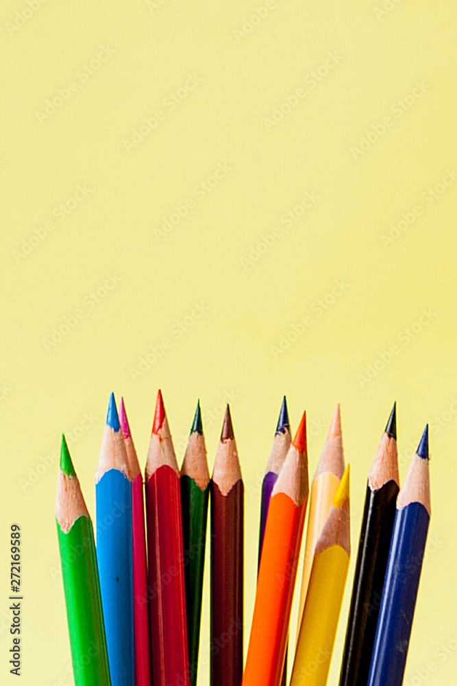 Row of colorful pencils on yellow background Row of colorful pencils on yellow background