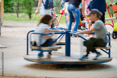 motion view of friendly children ride at the carousel, joyful kidss