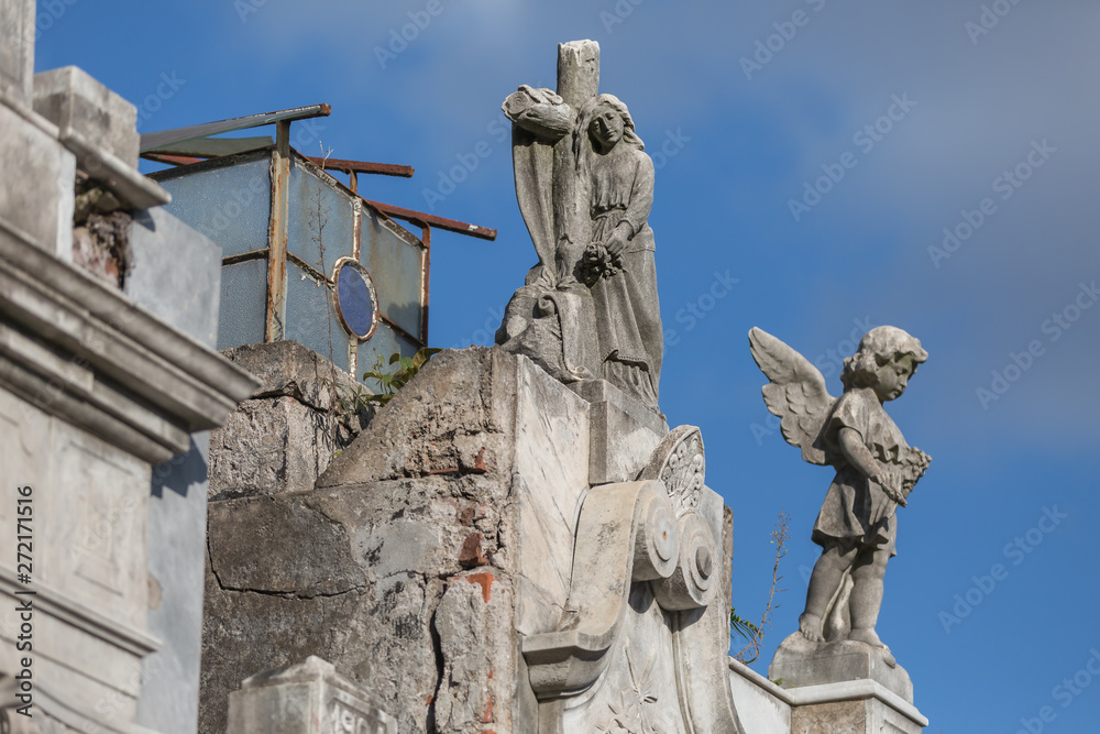 Mausoleum with lady and cross and child angel at cemetery