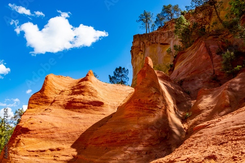 Large colorful ochre deposits, located in Roussillon, small Provensal town in  Natural Regional Park of Luberon, South of France © barmalini