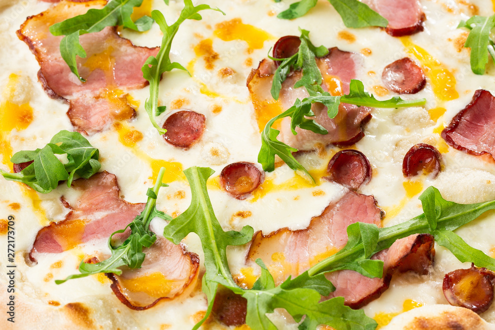 Pizza with ham , arugula (salad rocket), rucola and mozzarella  on  wooden background close up. Italian cuisine.