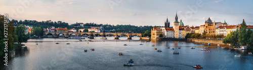 Scenic sunset summer panoramic view of Charles Bridge or Karluv most from Legions Bridge. Beautiful Prague quay, old Town pier and Vltava river with floating pleasure boats, Czech Republic