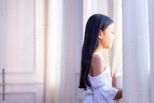 little asian girl looking out of window