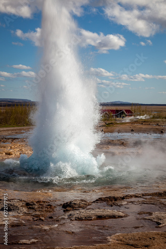 An erupting geyser in Iceland on a sunny day
