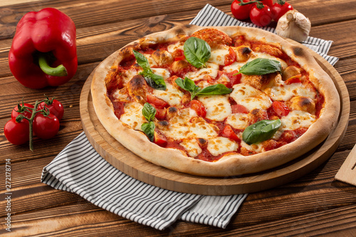 Pizza Margherita on wooden background, top view. Pizza Margarita with Tomatoes, Basil and Mozzarella Cheese close up. 