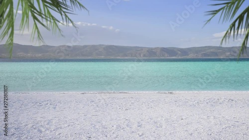 Salda lake with white sand and green water. Palm leaves wawing on the scene like Maldives. Yesilova Burdur Turkey. photo