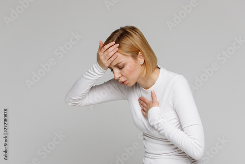 Breathing, respiratory problem, asthma attack, pressure, chest pain, dizziness concept. Studio portrait of exhausted or tired female having rest after a hard day, touching her forehead, isolated.