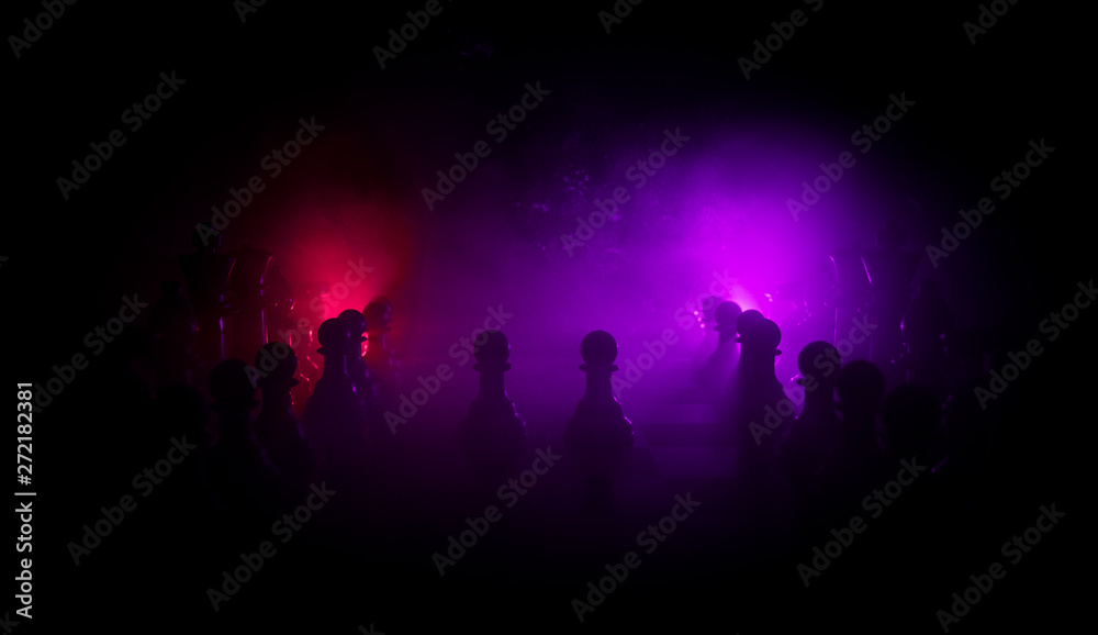 Chess board game concept of business ideas and competition. Chess figures on a dark background with smoke and fog.