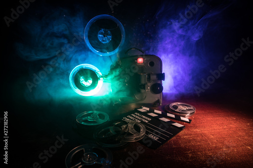 Old vintage movie projector on a dark background with fog and light. Concept of film-making.