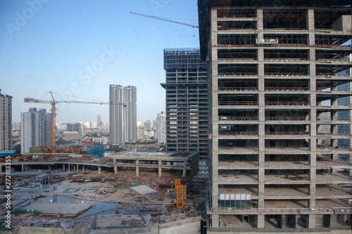 Buildings under construction. Chengdu, Sichuan, China. Construction site in downtown city during blue summer day. 