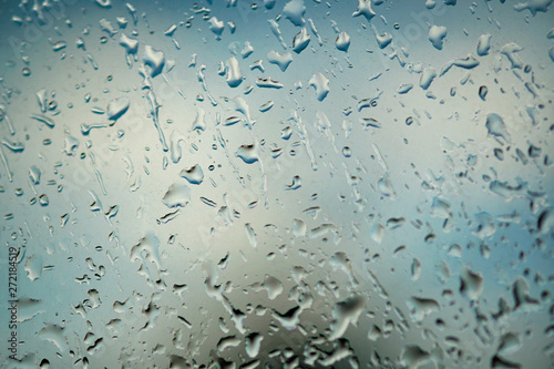 Large drops of rain on the window. It's a nasty day. Abstract blue background and texture, macro