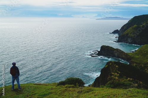 traveler standing at Cape Reinga and looking at the ocean