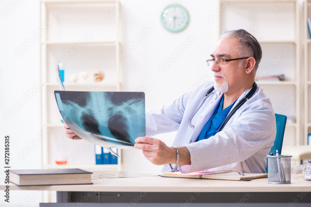 Obraz premium Old male doctor working in the clinic 