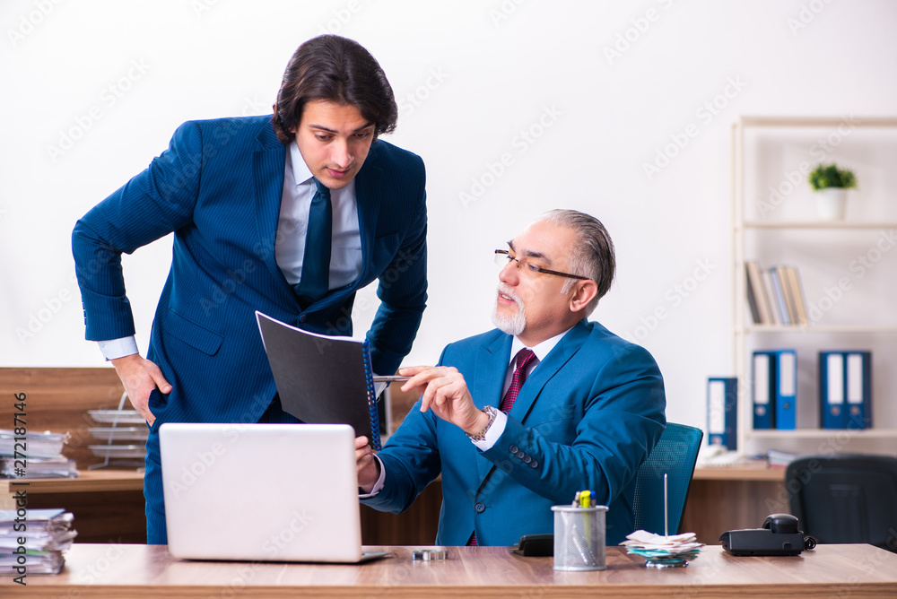 Young and old employees working together in the office Young and old employees working together in the office