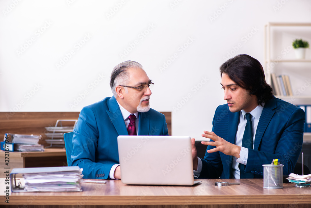 Young and old employees working together in the office Young and old employees working together in the office