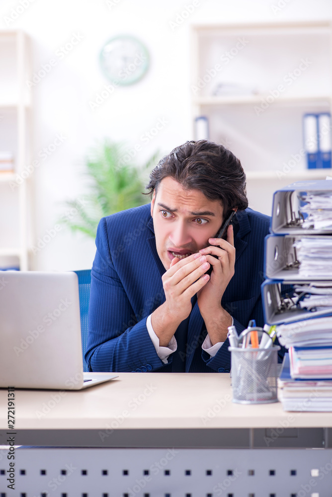 Young male employee unhappy with excessive work Young male employee unhappy with excessive work