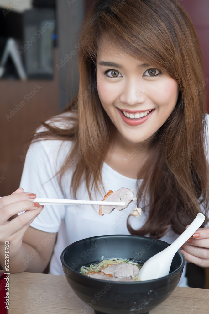 woman enjoying Chinese wonton or dumpling noodle with roasted duck woman enjoying Chinese wonton or dumpling noodle with roasted duck