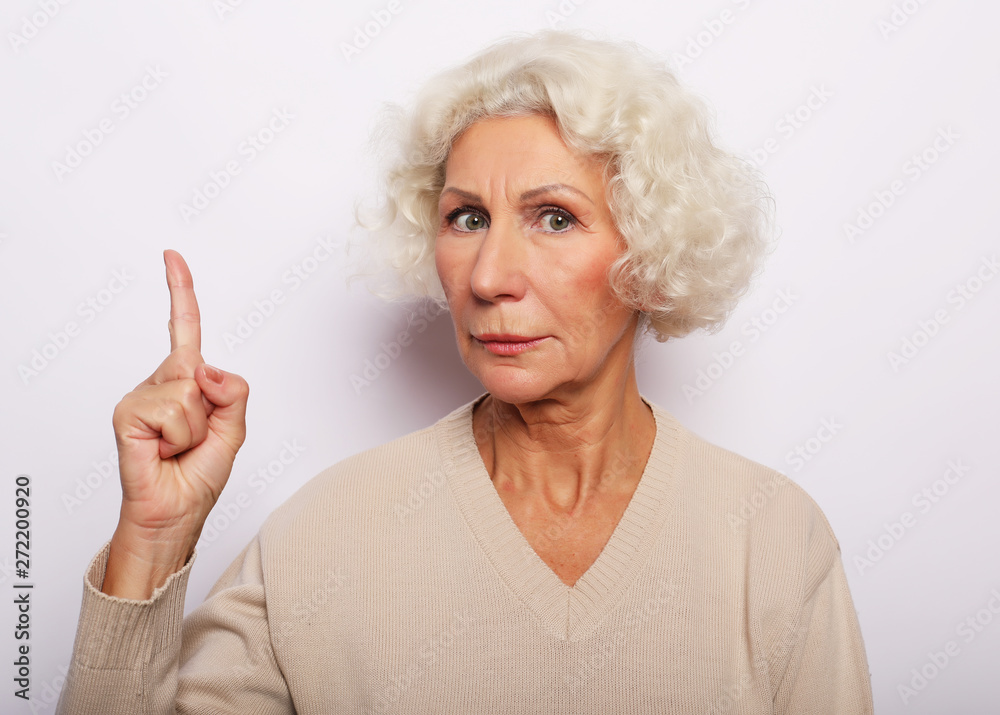 idea, attention and people concept - portrait of smiling senior woman pointing finger up over white background idea, attention and people concept - portrait of smiling senior woman pointing finger up over white background