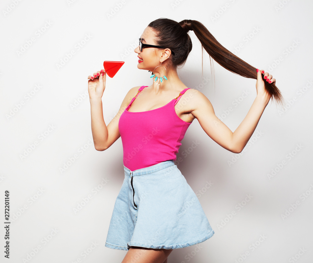 Attractive young woman with lollipop in hands over white background Attractive young woman with lollipop in hands over white background
