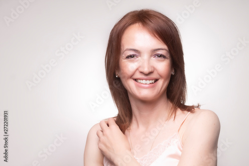 one mature woman smiling to a camera.