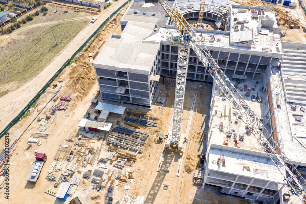 drone image of industrial machinery at construction site. office building under construction.