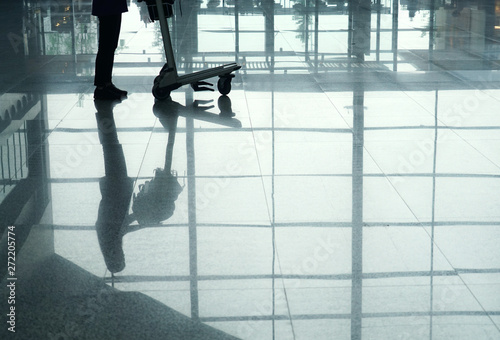 tourist with cart reflection in floor in airport