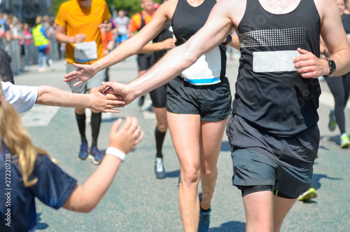 Fotografija Marathon running race,runners support on road race, child's hand giving highfive