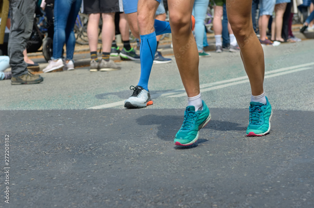 Marathon running race, many runners feet on road racing, sport competition, fitness and healthy lifestyle concept Marathon running race, many runners feet on road racing, sport competition, fitness and healthy lifestyle concept