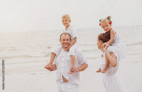 Happy young family on the sunset at the beach.