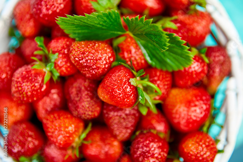 Fototapeta Naklejka Na Ścianę i Meble -  Ripe red strawberries on blue table, Strawberries in white basket. Fresh strawberries. Beautiful strawberries. Diet food. Healthy, vegan. Top view. Flat lay.