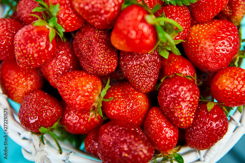 Ripe red strawberries on blue table  Strawberries in white basket. Fresh strawberries. Beautiful strawberries. Diet food. Healthy  vegan. Top view. Flat lay.