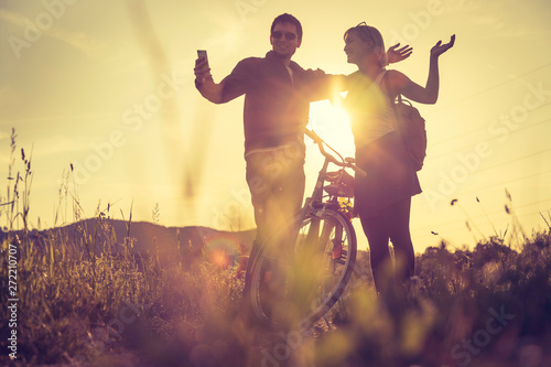 Foto Sundown scenery with young couple: Boy and girl are doing a gesture