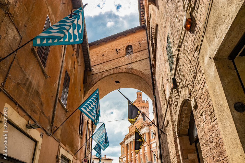 Φωτογραφία An alley in the historic center of Foligno, with blue, black and yellow flags of the districts