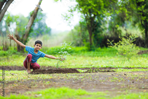 young indian cute child planting tree 