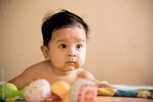 Cute baby playing with toys on the bed