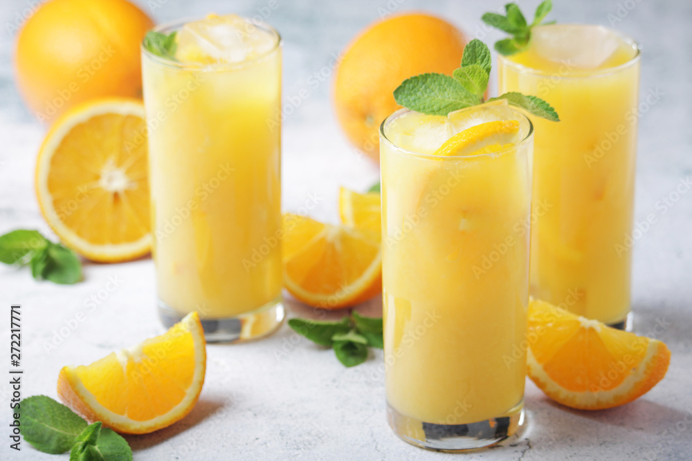 Glasses full of orange juice with ice Glasses full of orange juice with ice